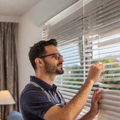 Man installing blinds in a multifamily to increase tenant retention.